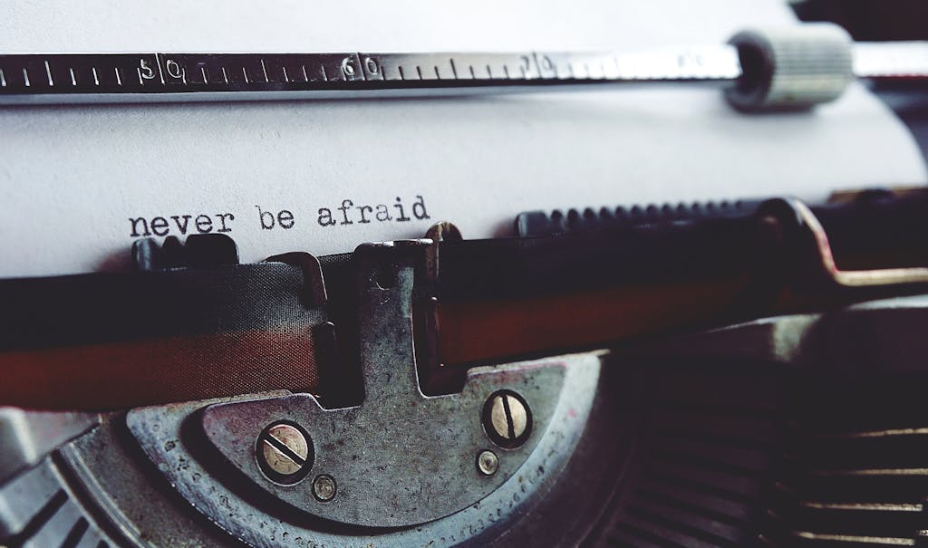 Close-up of a vintage typewriter with the message 'never be afraid' on paper.